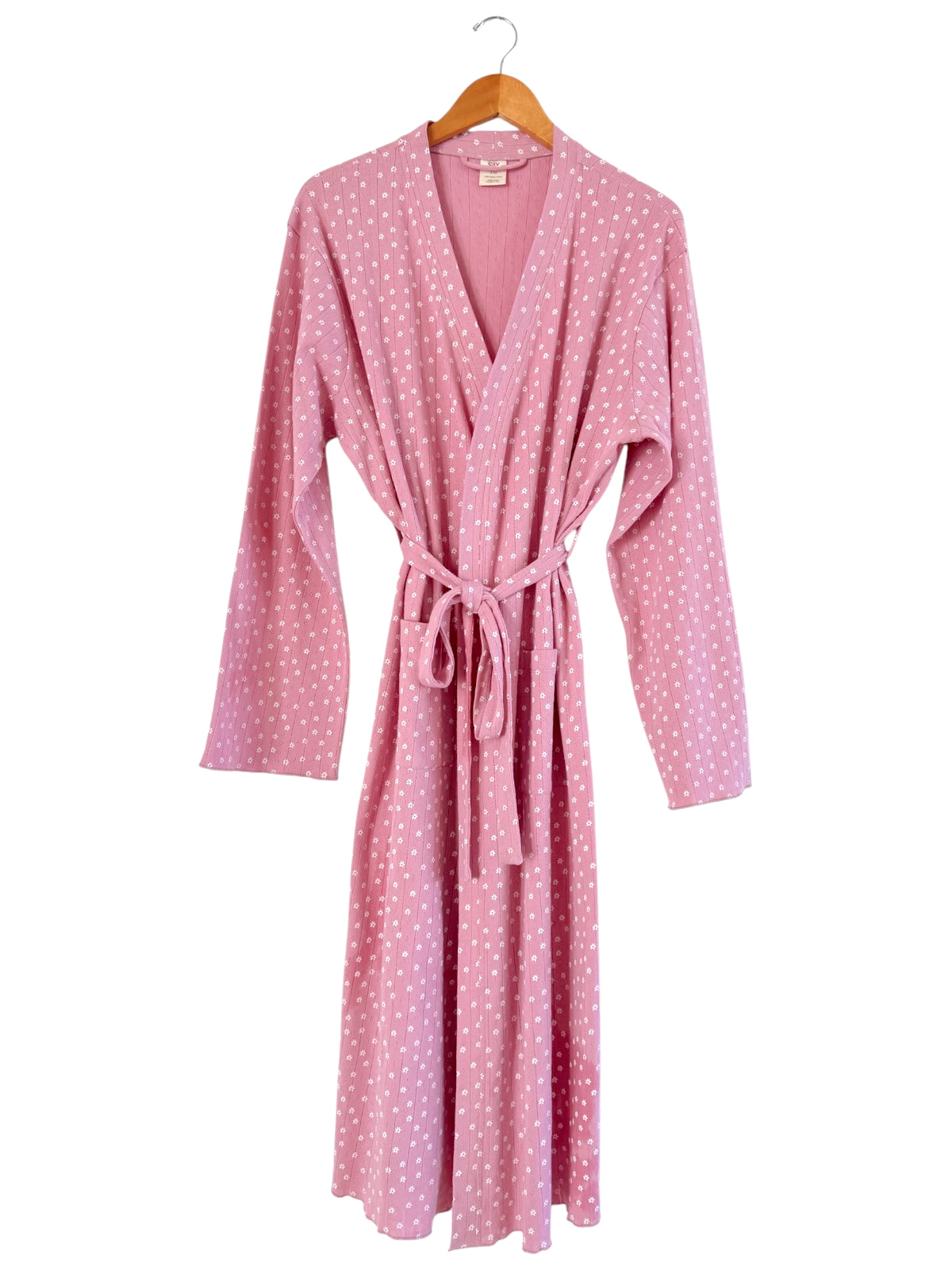 Pink robe with white polka dots, featuring long sleeves and a tied waist, displayed on a wooden hanger.