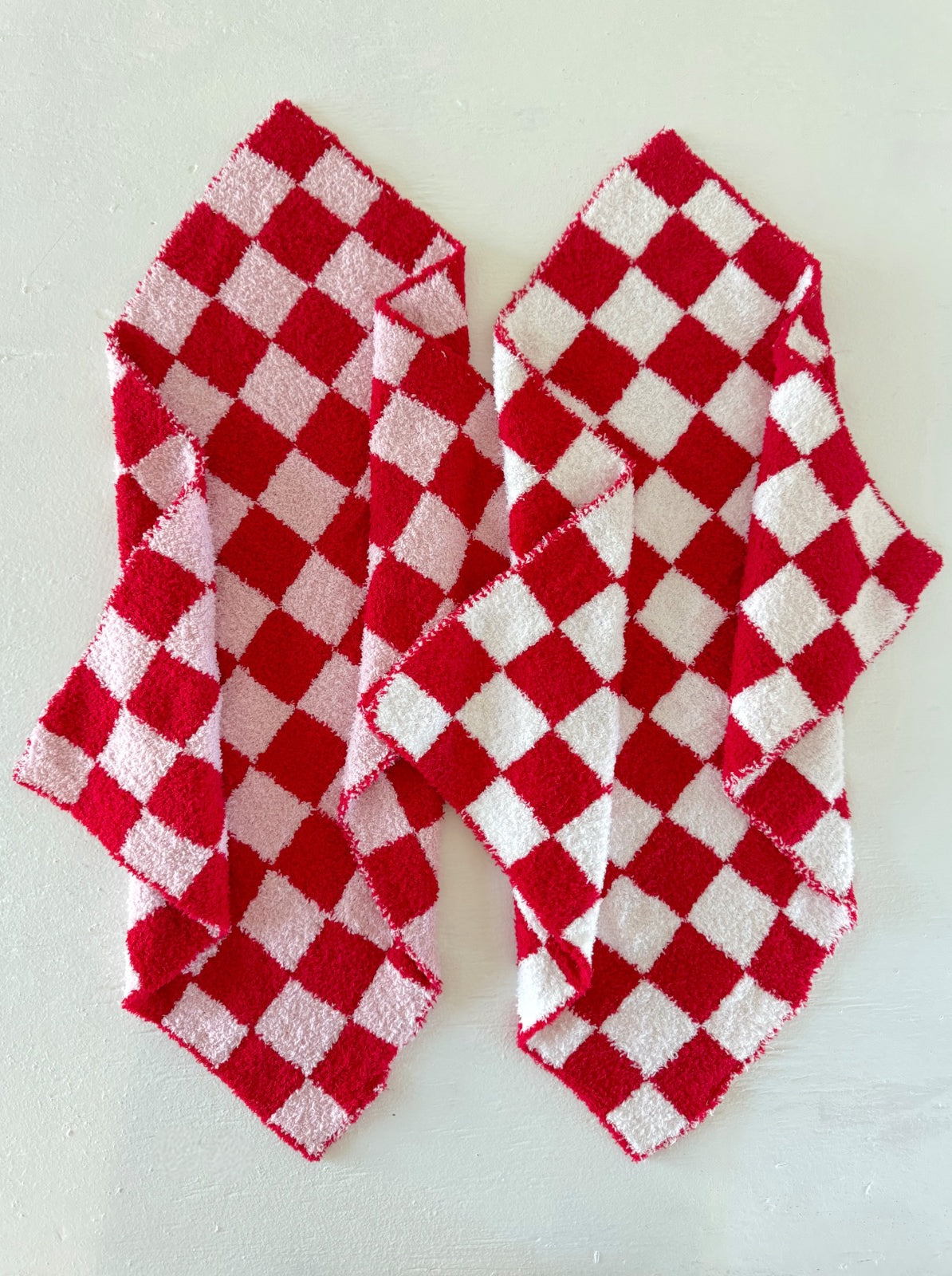 Two red and white checkered towels displayed against a light background.
