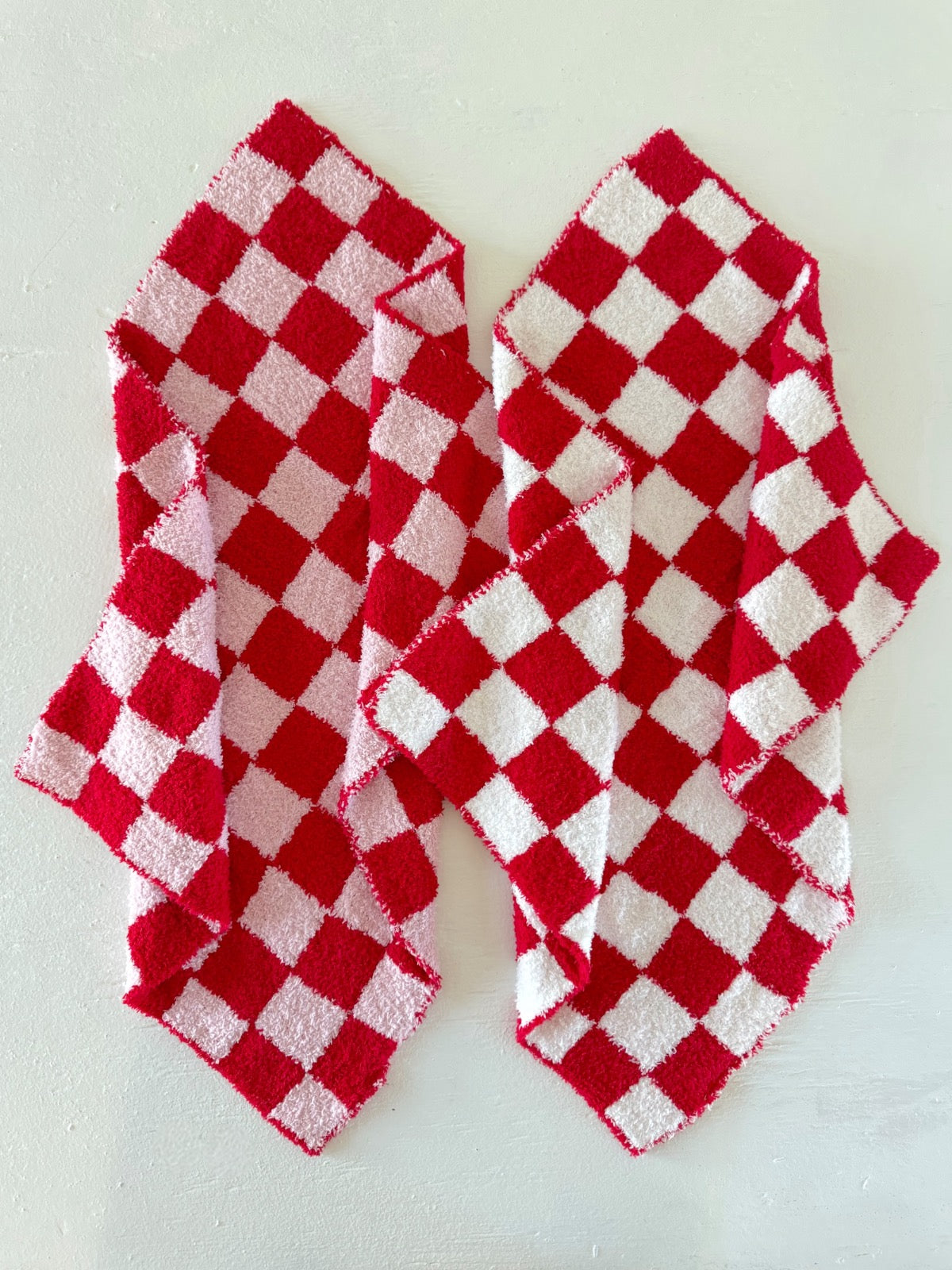 Two red and white checkered towels displayed against a light background.