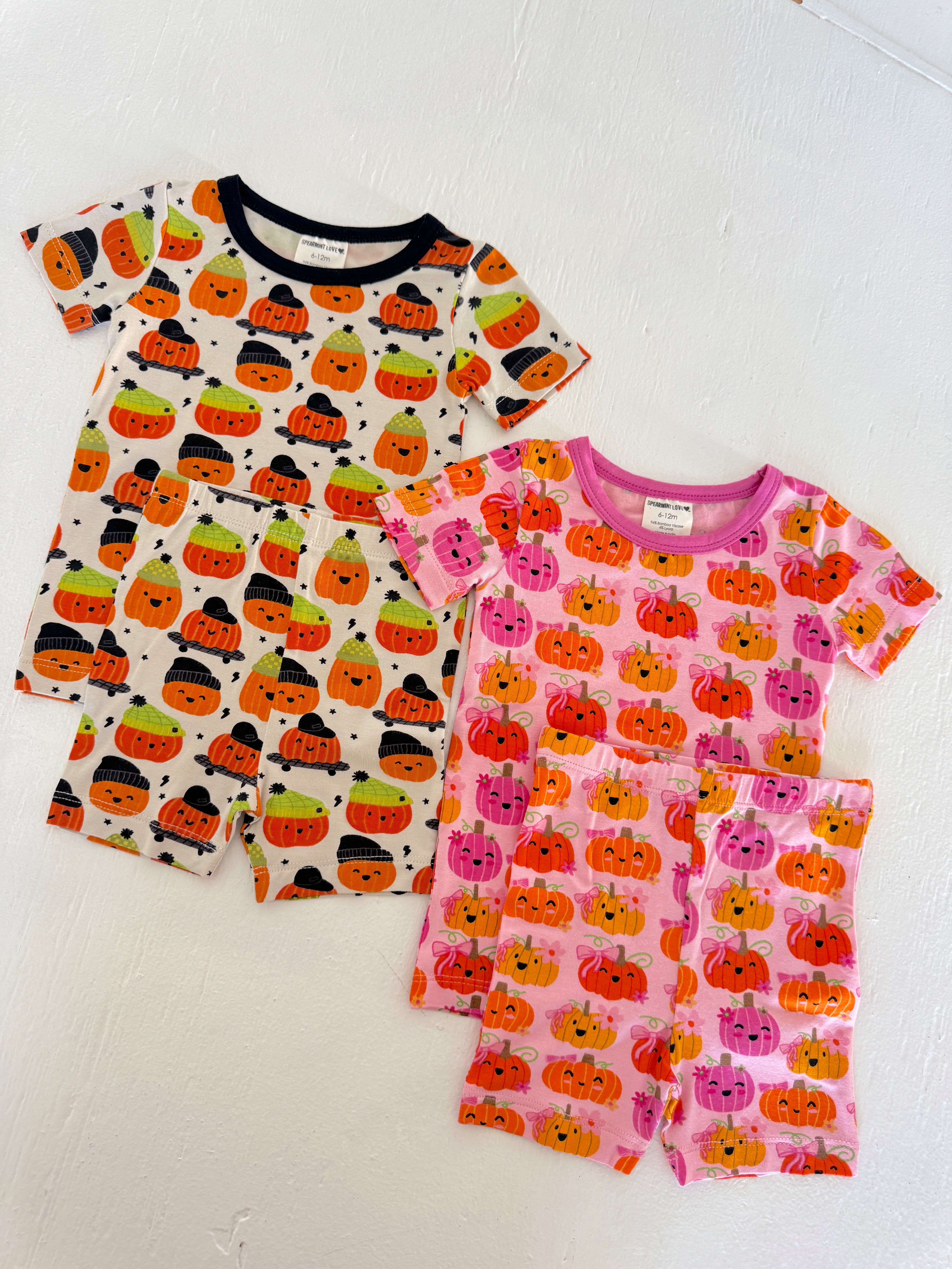 Two sets of toddler pajamas featuring colorful pumpkin designs, ideal for Halloween festivities.