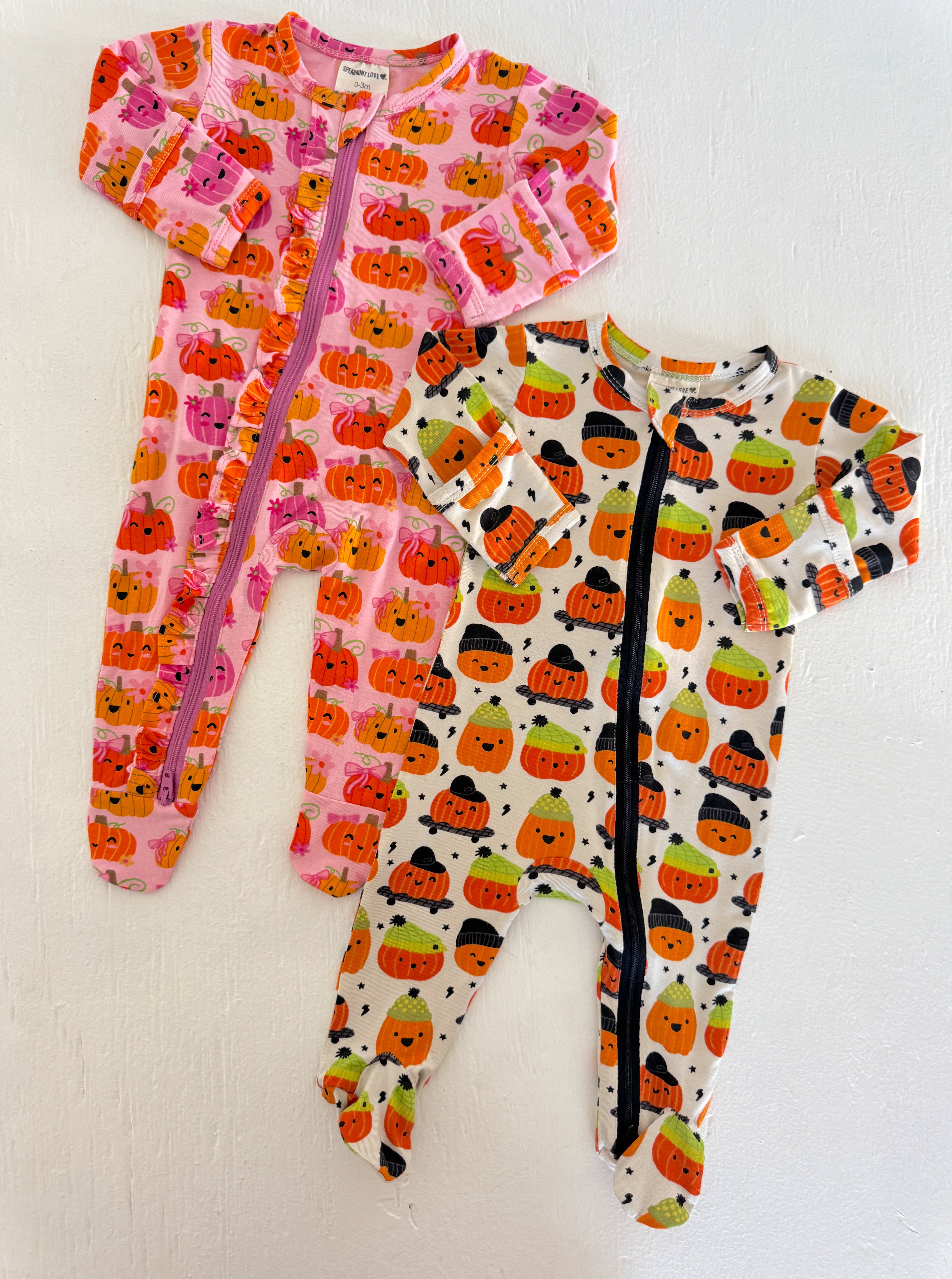 Two playful pumpkin-themed toddler pajamas in pink and white. Perfect for cozy fall nights.