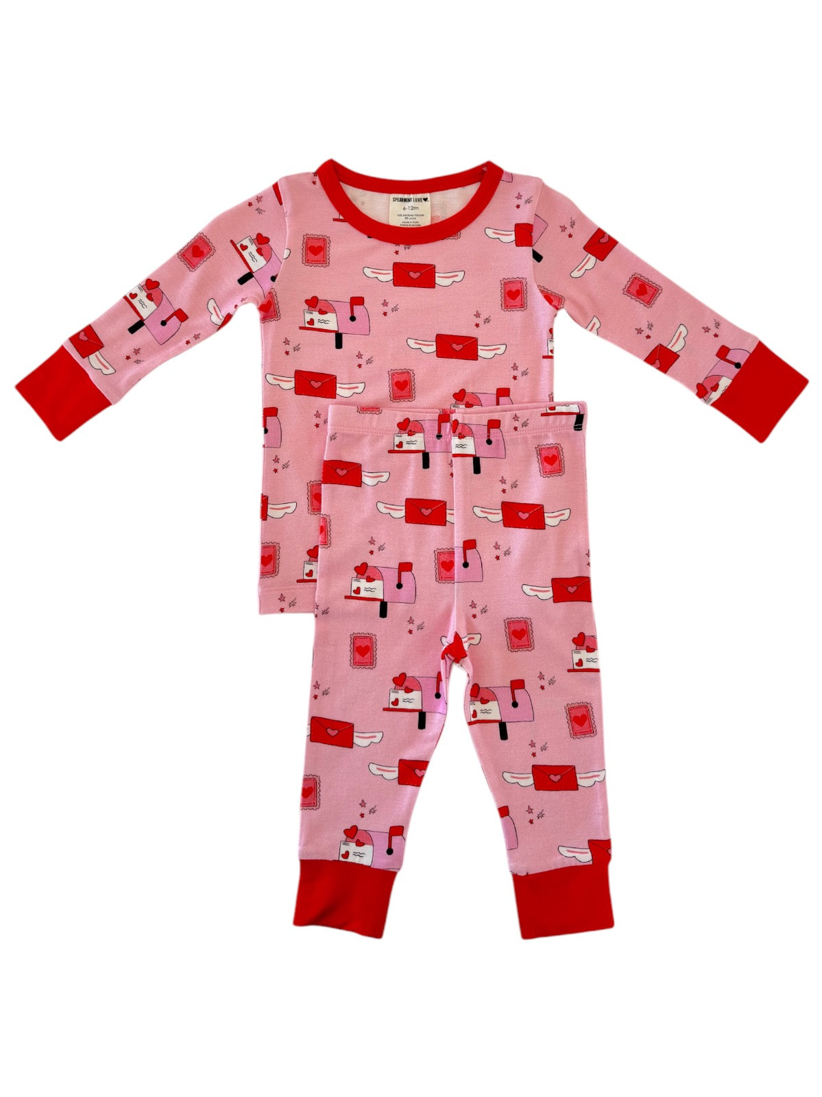 Pink children's pajamas with red accents and a playful mailbox and heart pattern. Perfect for cozy nights.