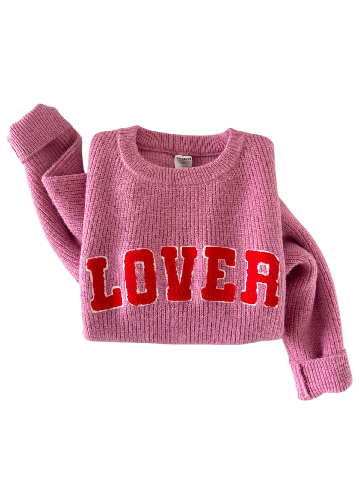 Pink sweater with "LOVER" in bold red letters, showcasing a cozy, stylish knit design.