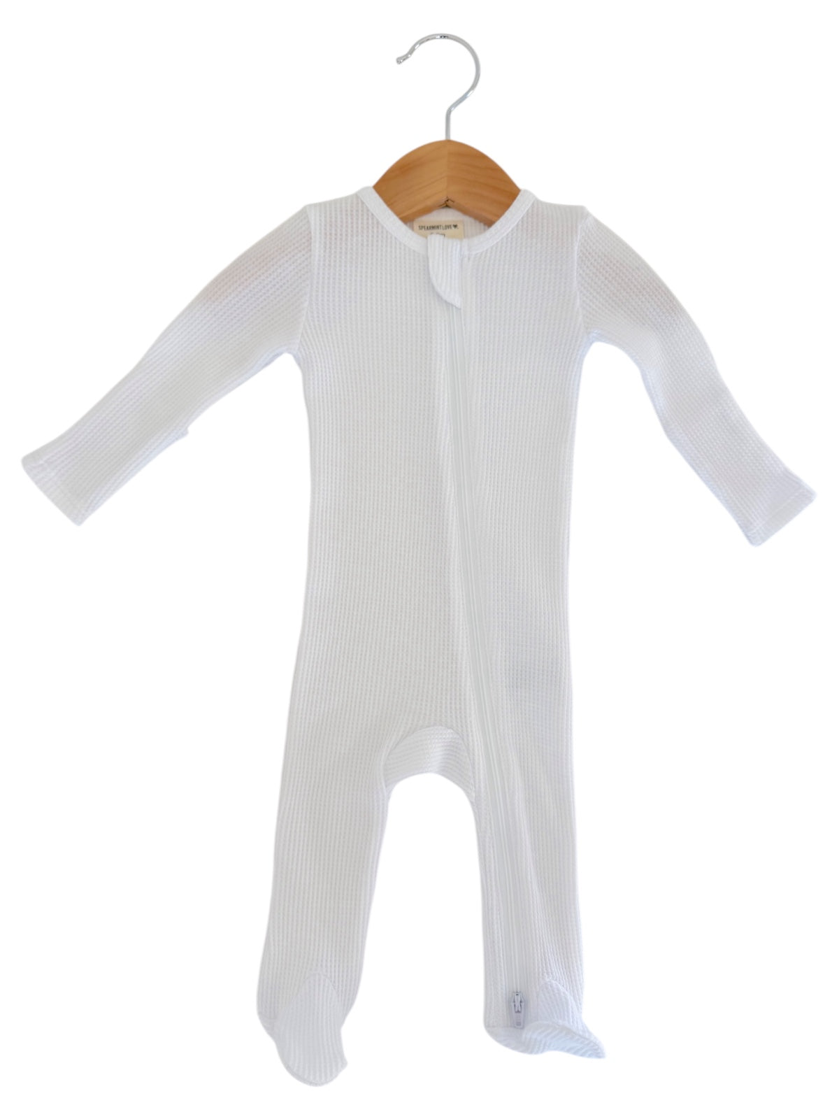 White baby onesie on a wooden hanger against a plain background. Ideal for infant sleepwear or lounging.