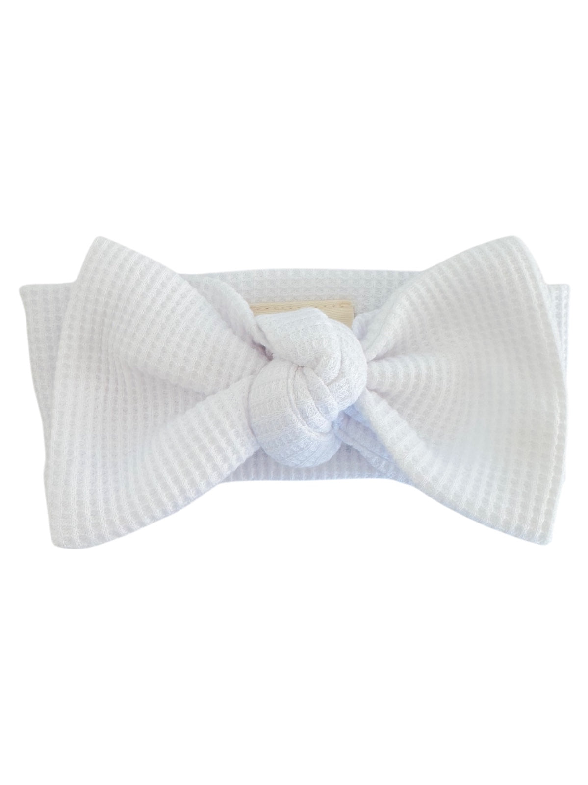 White fabric headband with a large bow and knot detail, featuring a textured pattern.