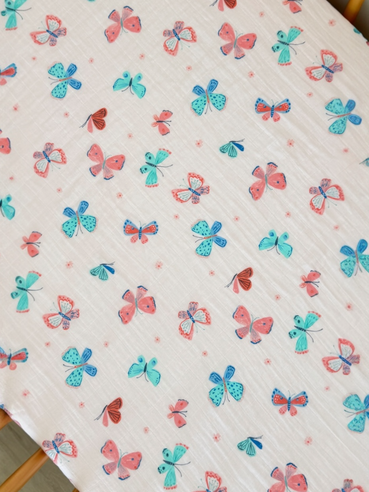 Colorful butterflies in various shades of blue, pink, and green on a light cream background.