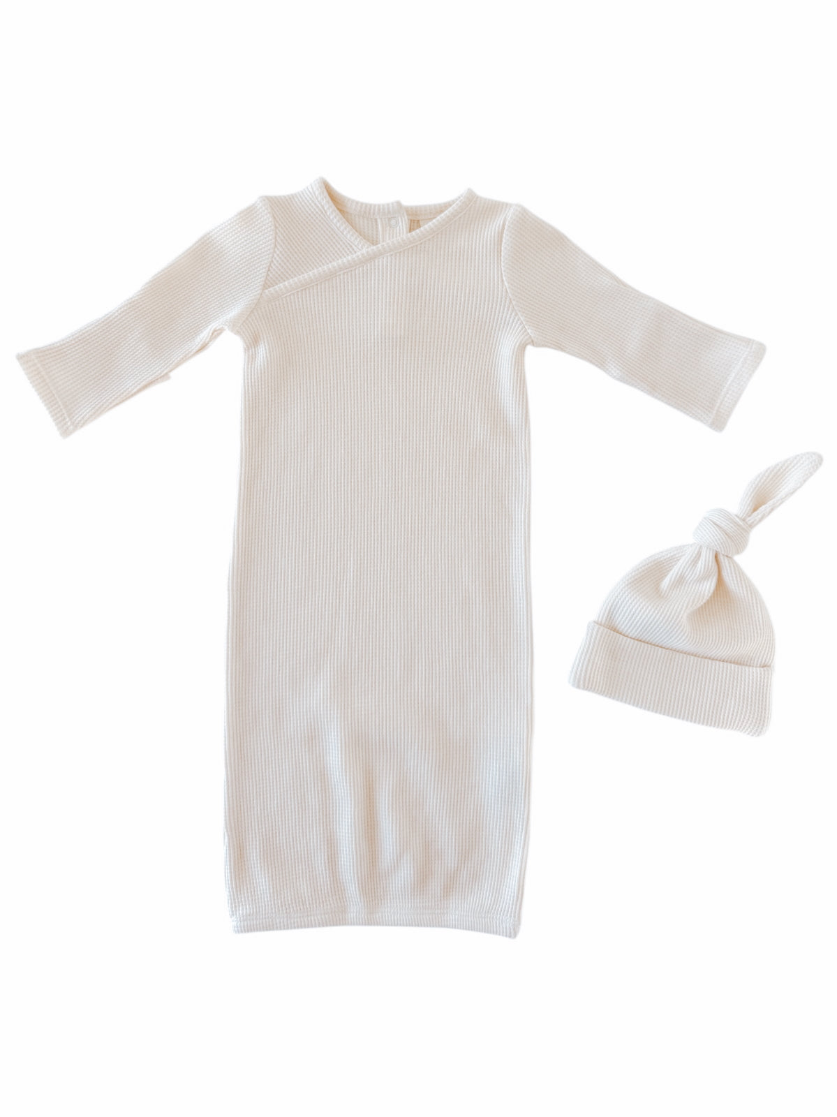 Light beige newborn gown and matching knotted hat, made of soft ribbed fabric.