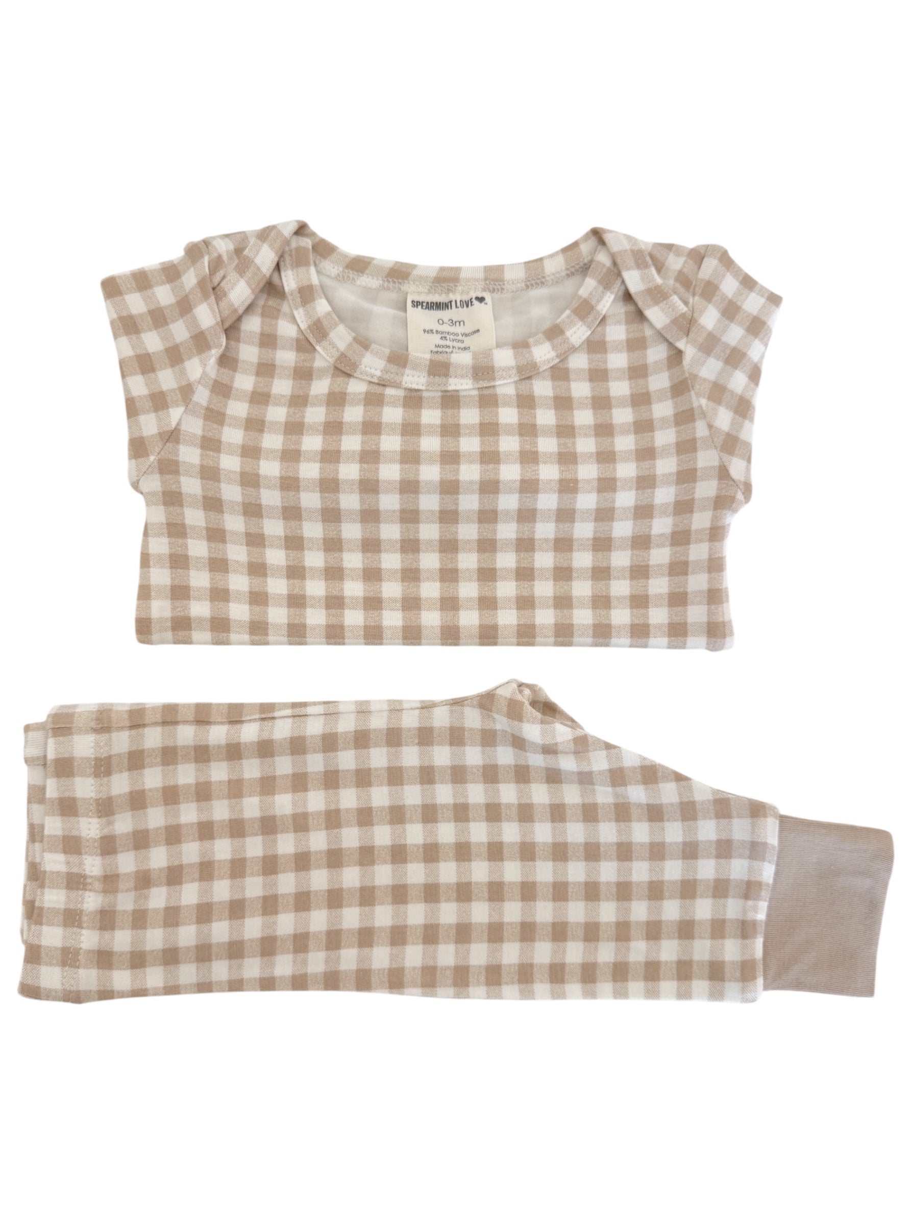 Tan and cream checkered infant pajamas, featuring a short-sleeve top and long pants, labeled size 0-3 months.