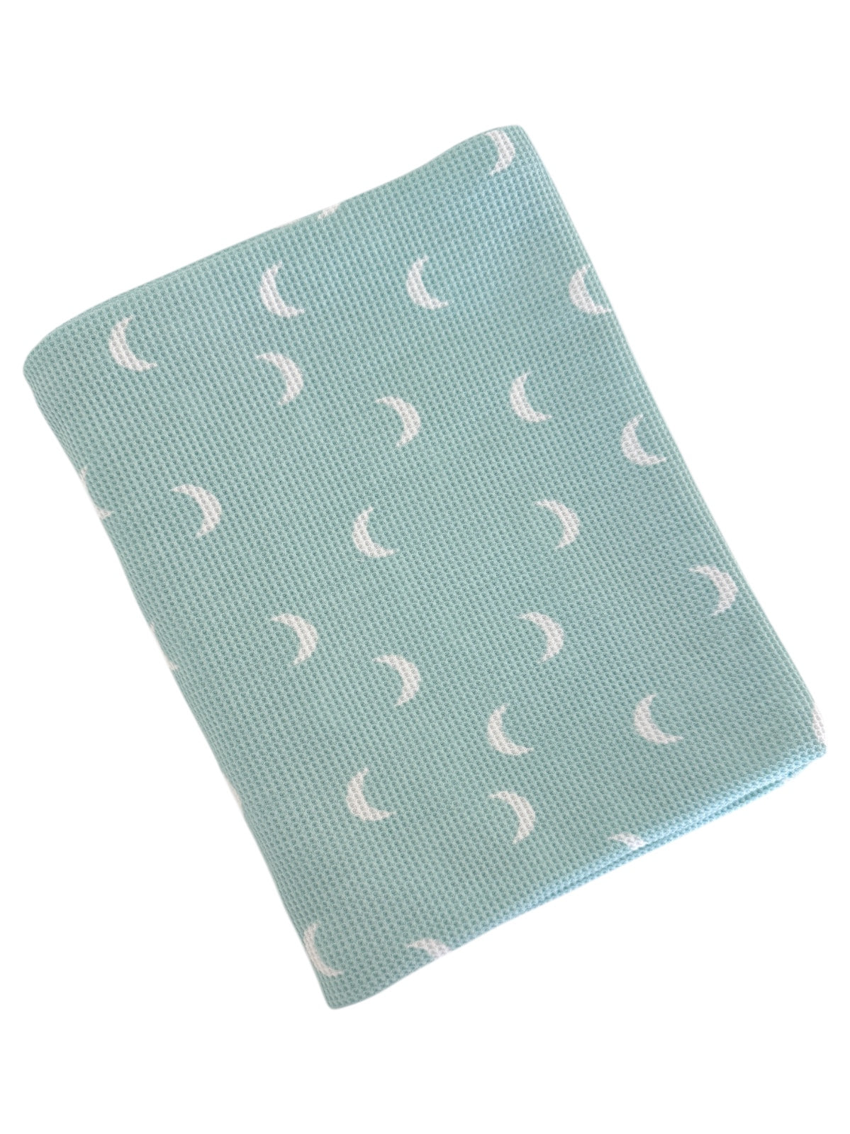 A light blue blanket with a textured pattern of white crescent moons.