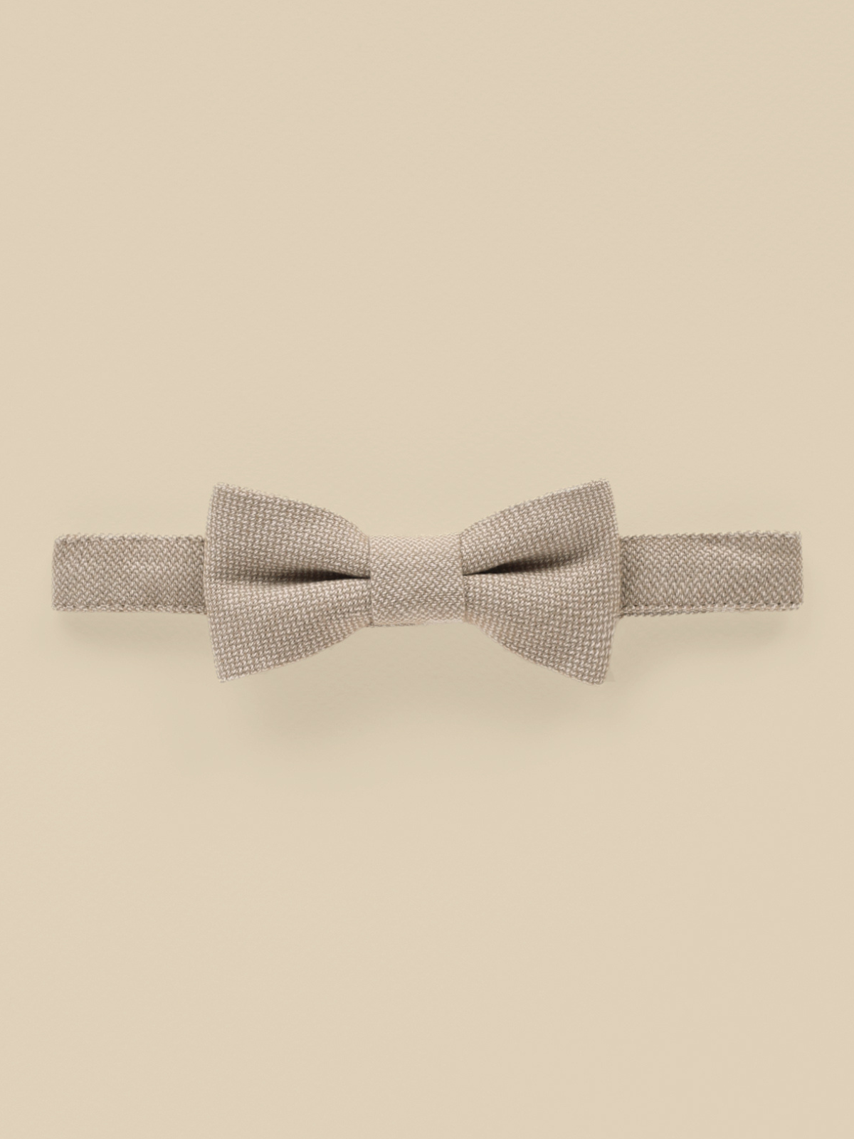 Beige bow tie on a light background, showcasing a textured fabric design. Perfect for formal occasions.