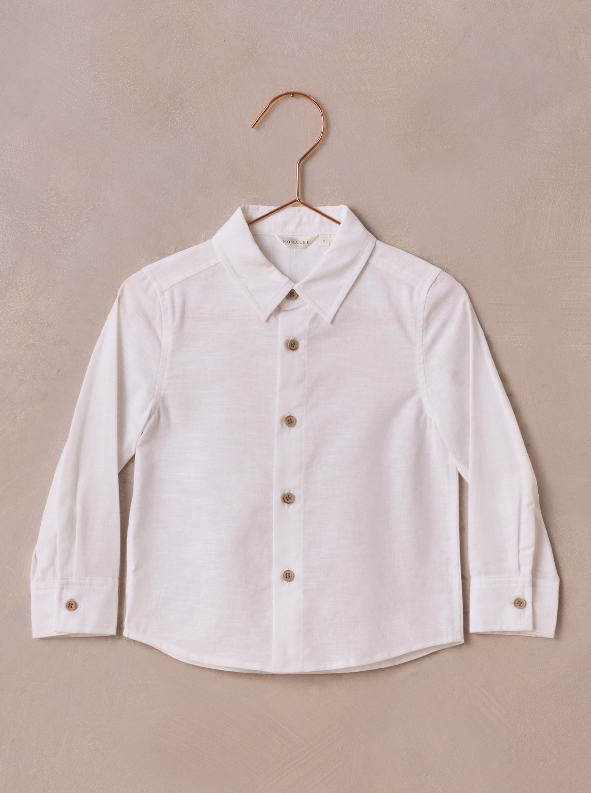 White long-sleeve button-up shirt on a copper hanger against a neutral background.