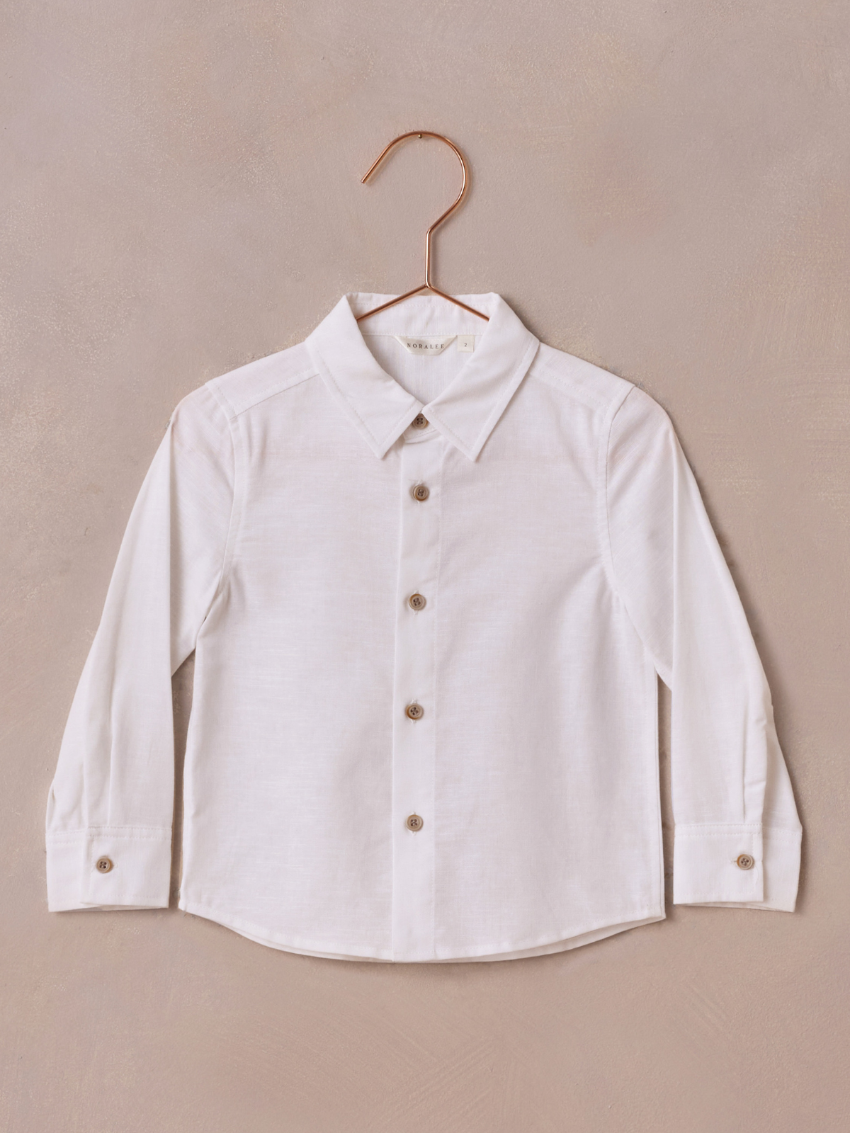 White long-sleeve button-up shirt on a copper hanger against a neutral background.