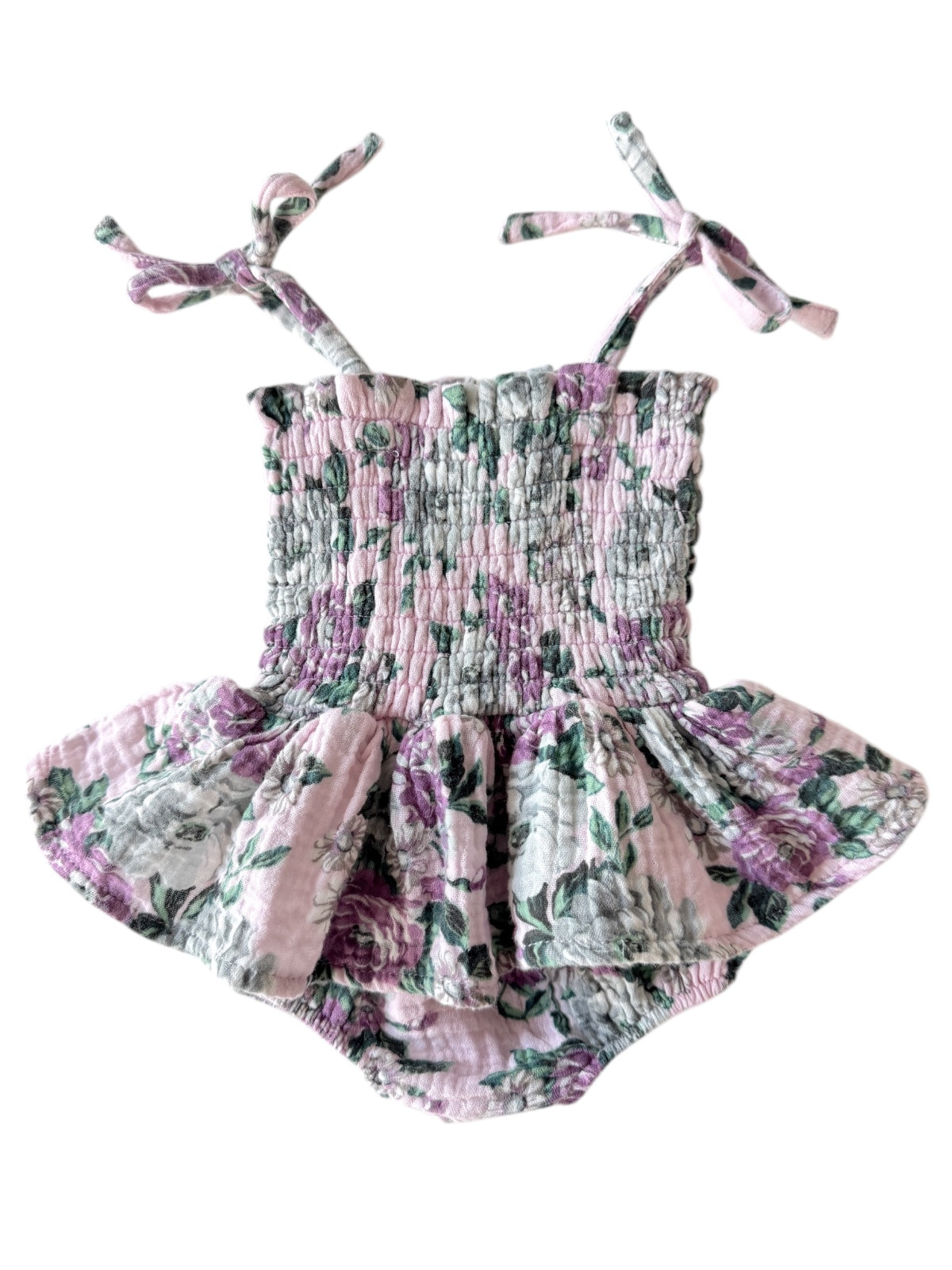 Floral-patterned baby swimsuit with ruffled bottom and tie straps in pastel pink and green hues.