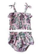Floral baby girl two-piece outfit featuring a smocked top and ruffled straps, paired with matching bloomer shorts.