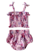 Floral two-piece outfit featuring a smocked top and ruffled shorts in shades of pink and purple.