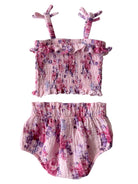 Pink floral baby outfit featuring a ruffled top with tie straps and matching bloomers, ideal for warm weather.