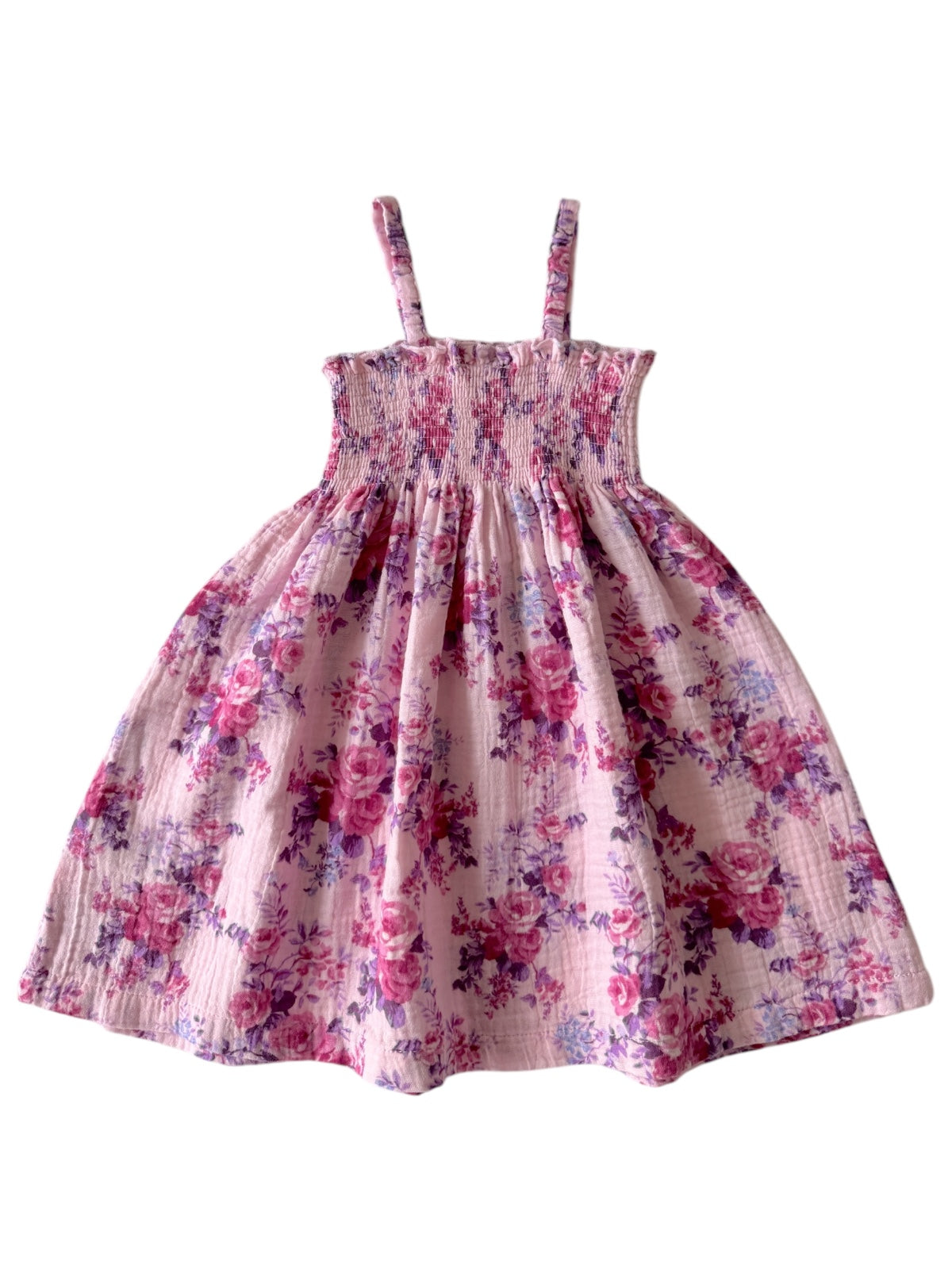 Pink floral dress with spaghetti straps, featuring a smocked bodice and a flowing skirt. Ideal for spring or summer wear.