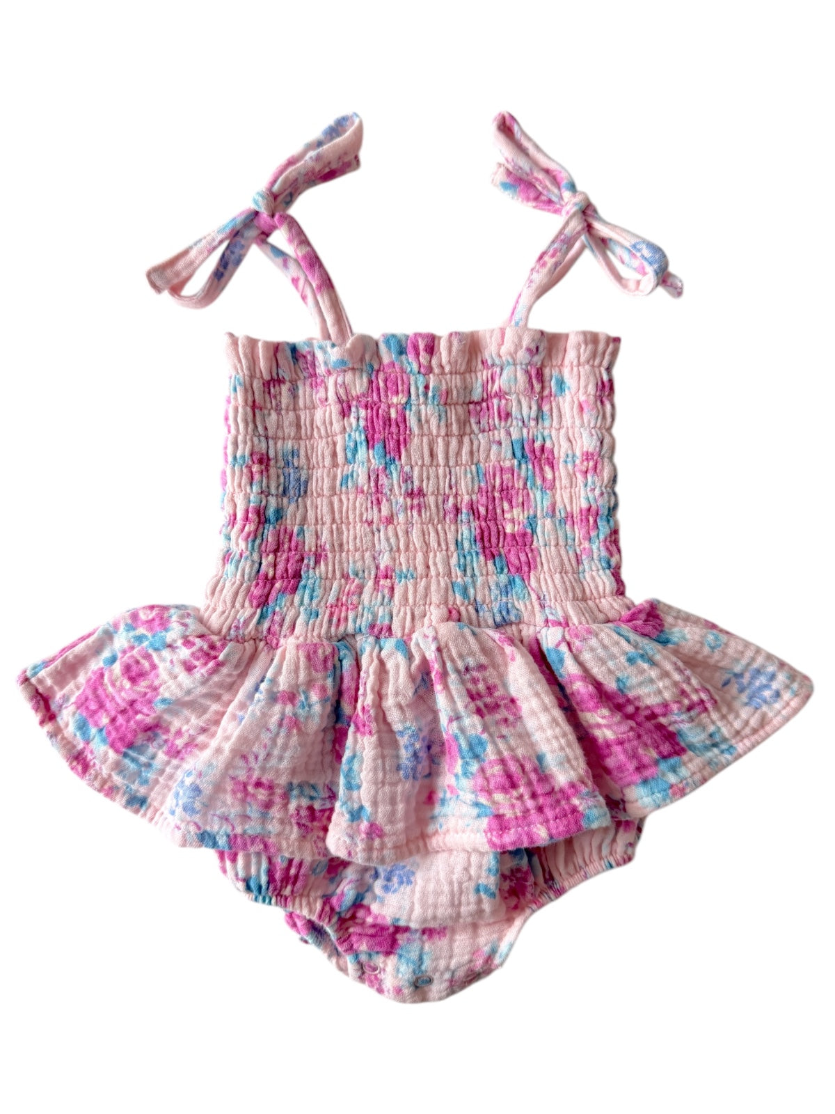 Pink floral toddler romper with tie straps and ruffled skirt, made from soft, lightweight fabric.