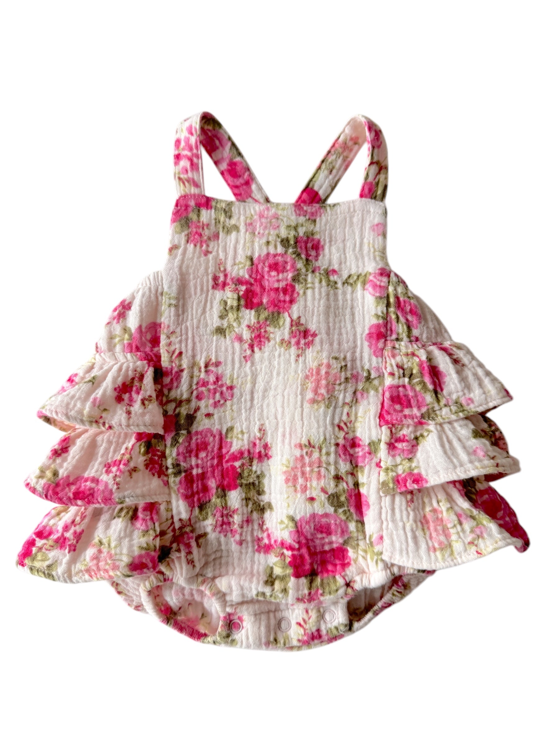 Floral baby dress with ruffles in pink and white, featuring adjustable straps and snap closures.