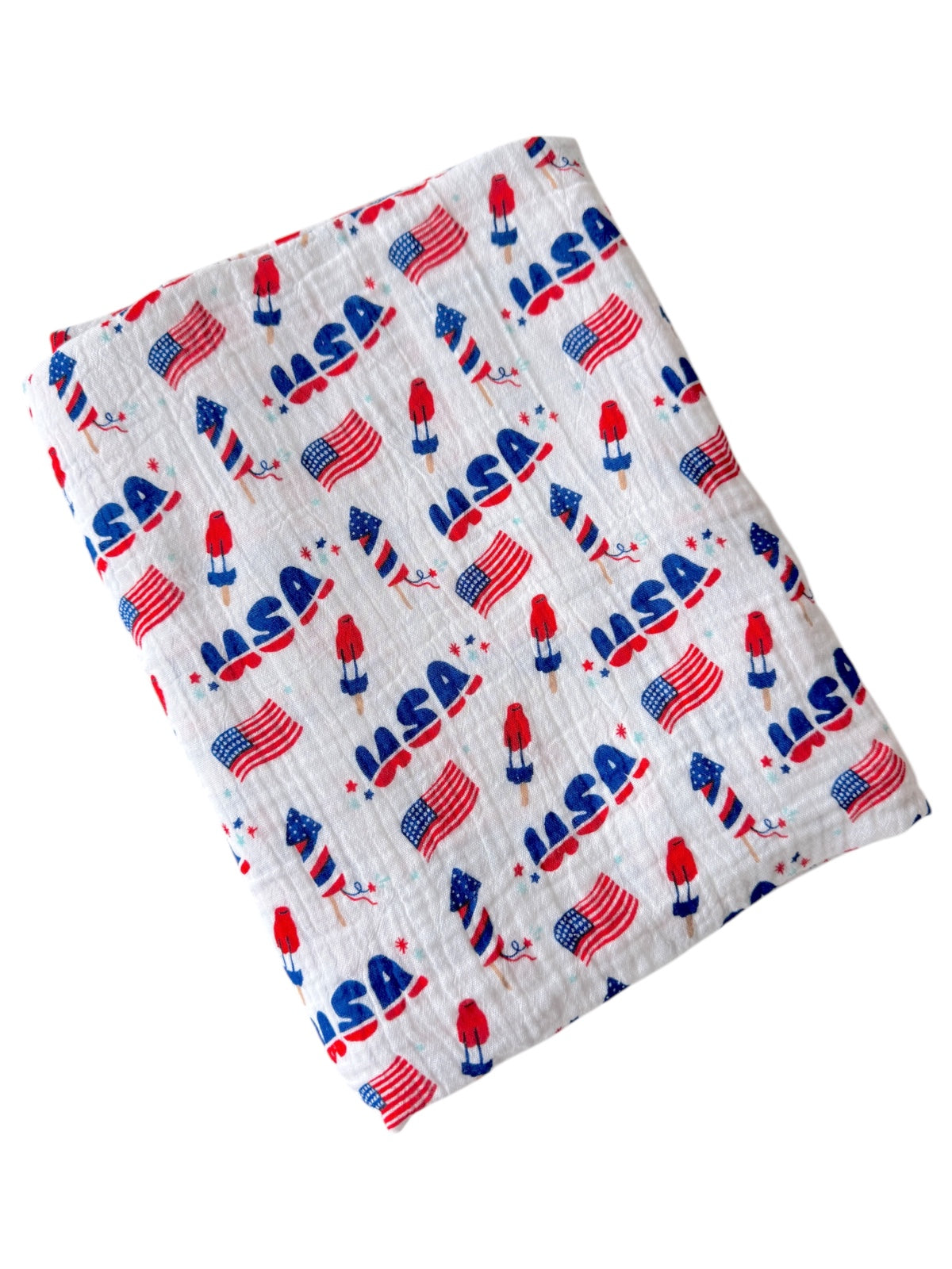 White fabric featuring red, blue rockets and flags with "USA" design, suitable for patriotic themes.