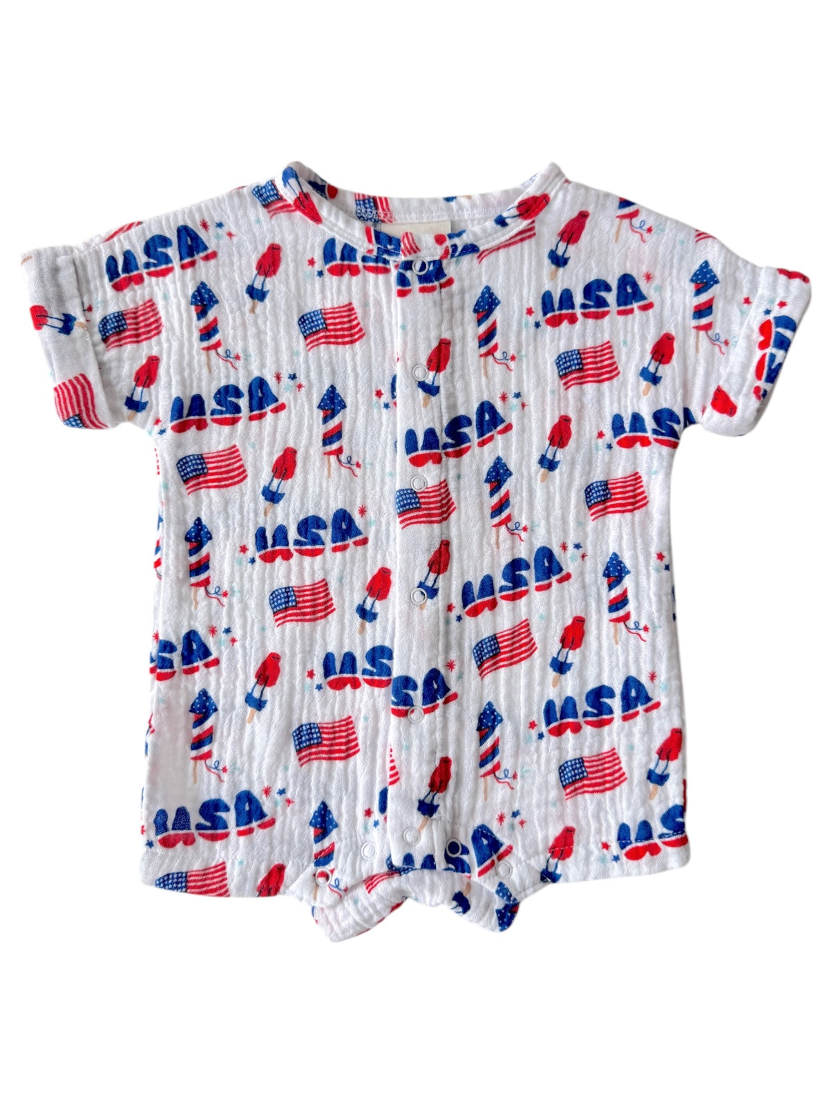 White short-sleeve onesie featuring a playful pattern of USA flags and patriotic elements.