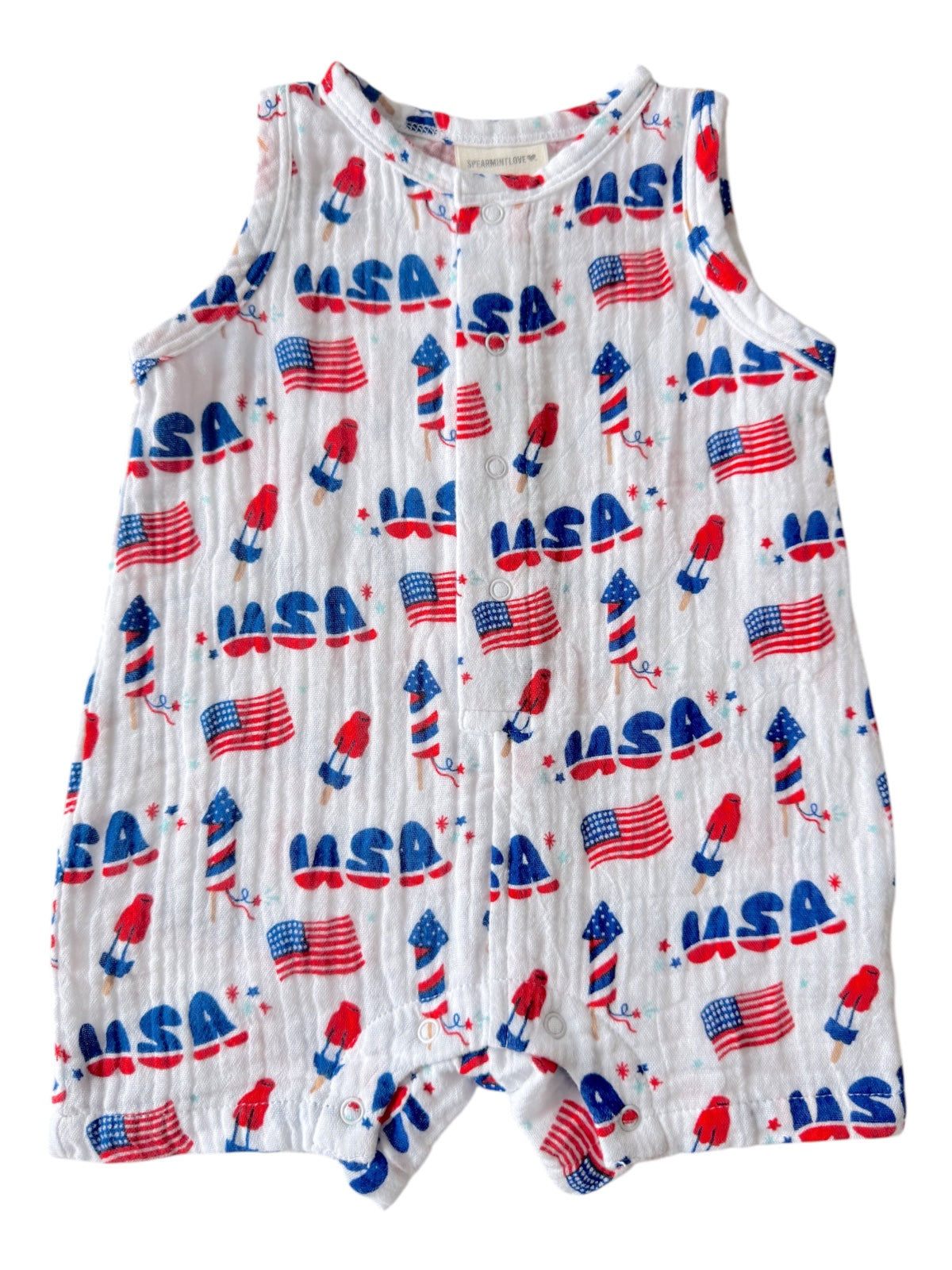 White onesie with red and blue USA-themed patterns, including rockets and flags.