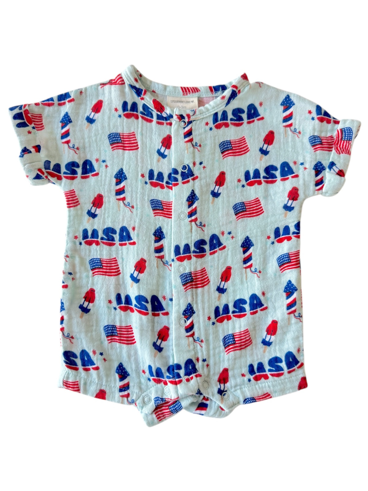 Children's onesie covered in rockets and USA flags on a light blue background.