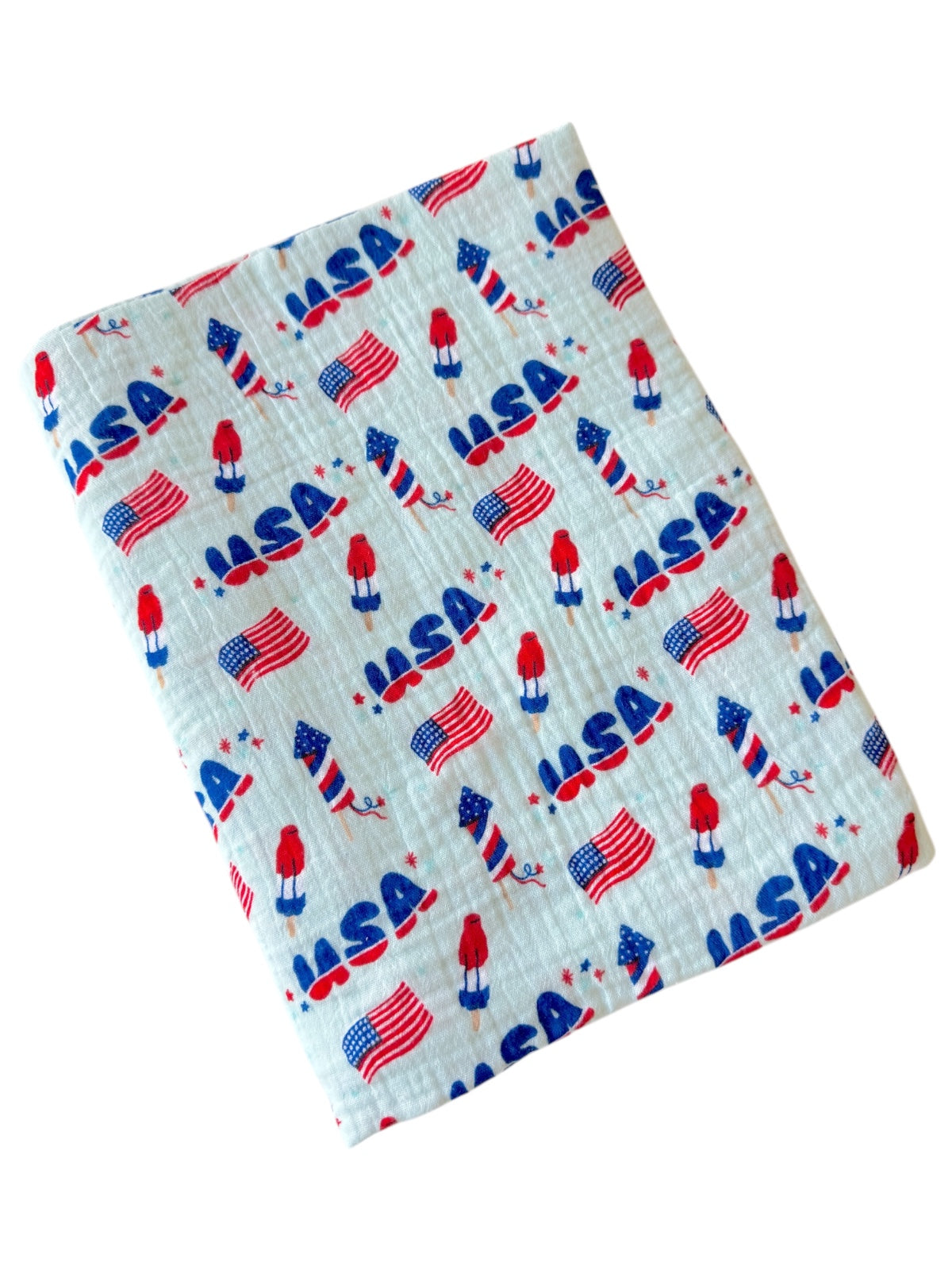USA-themed fabric featuring rockets, flags, and red figures on a light background. Perfect for festive projects.