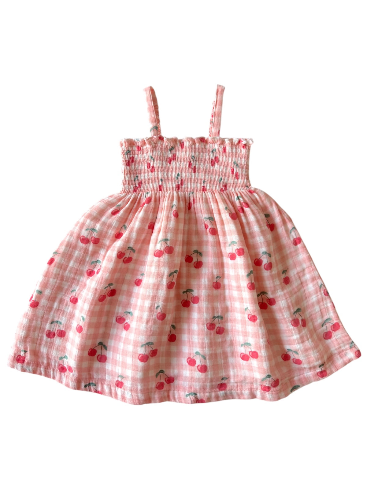 Pink dress with cherry print and smocked bodice, featuring thin straps and a flared skirt.