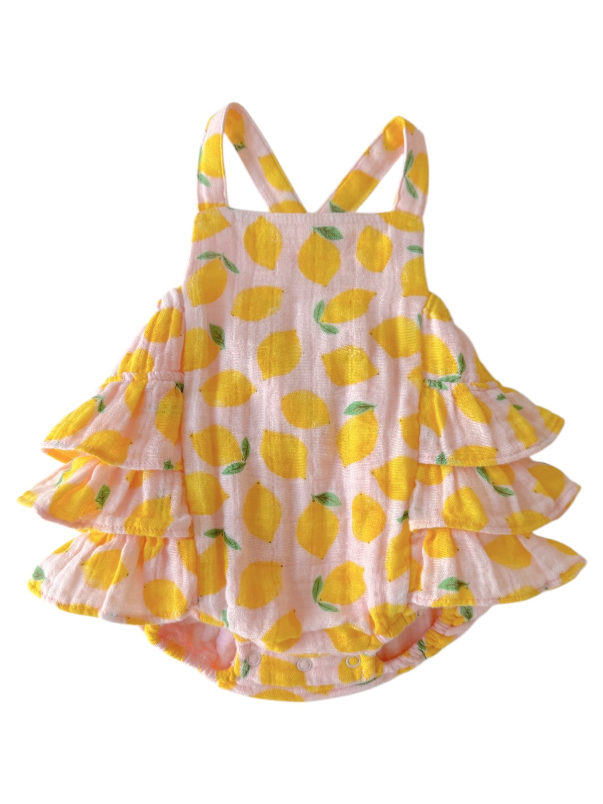 Yellow lemon-patterned toddler dress with ruffles and adjustable straps on a light pink background.