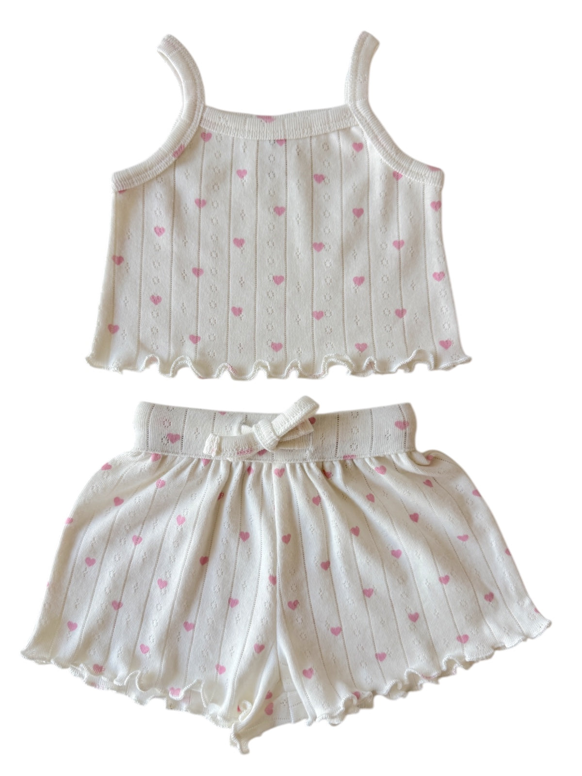 White tank top and shorts set with pink heart patterns, featuring a ruffled hem and adjustable waistband.