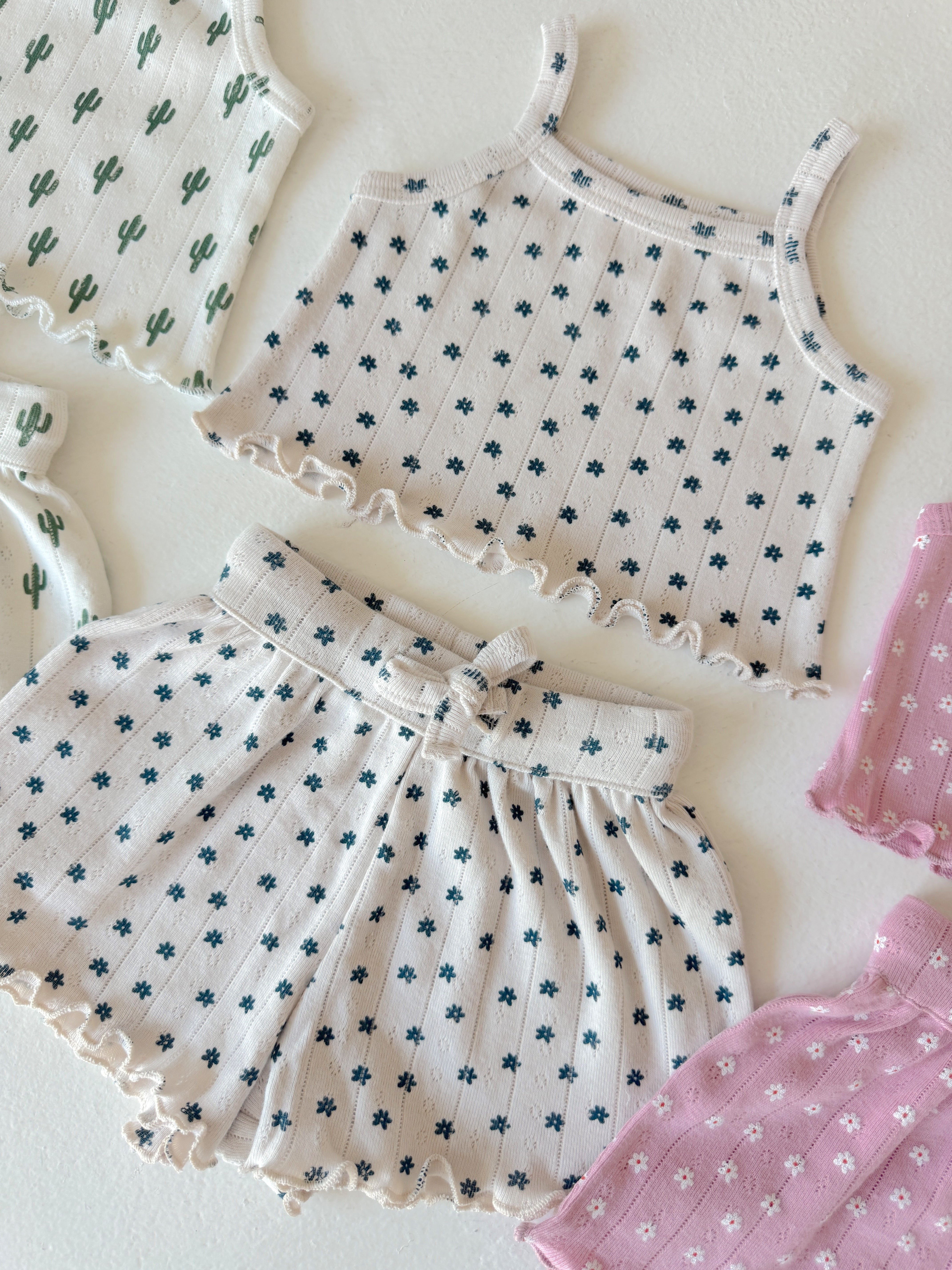 Lightweight children's clothing set featuring floral patterns, including tops and shorts in soft pastel colors.
