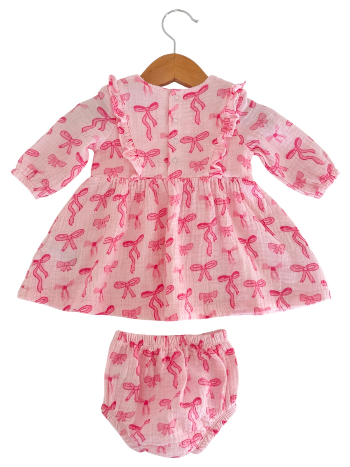 Pink floral dress with matching bloomers, featuring a ruffled collar and bow patterns.