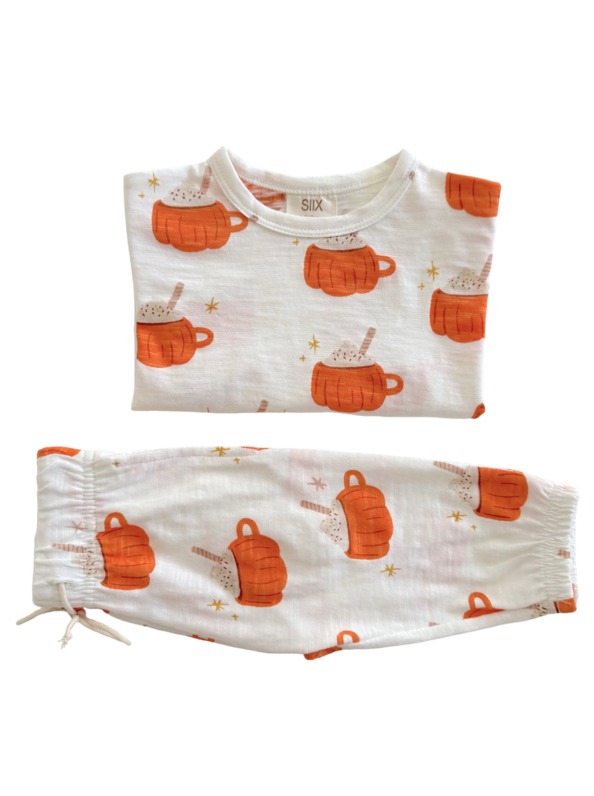Two-piece pajama set featuring orange mugs and hot chocolate print on white fabric. Ideal for cozy nights.
