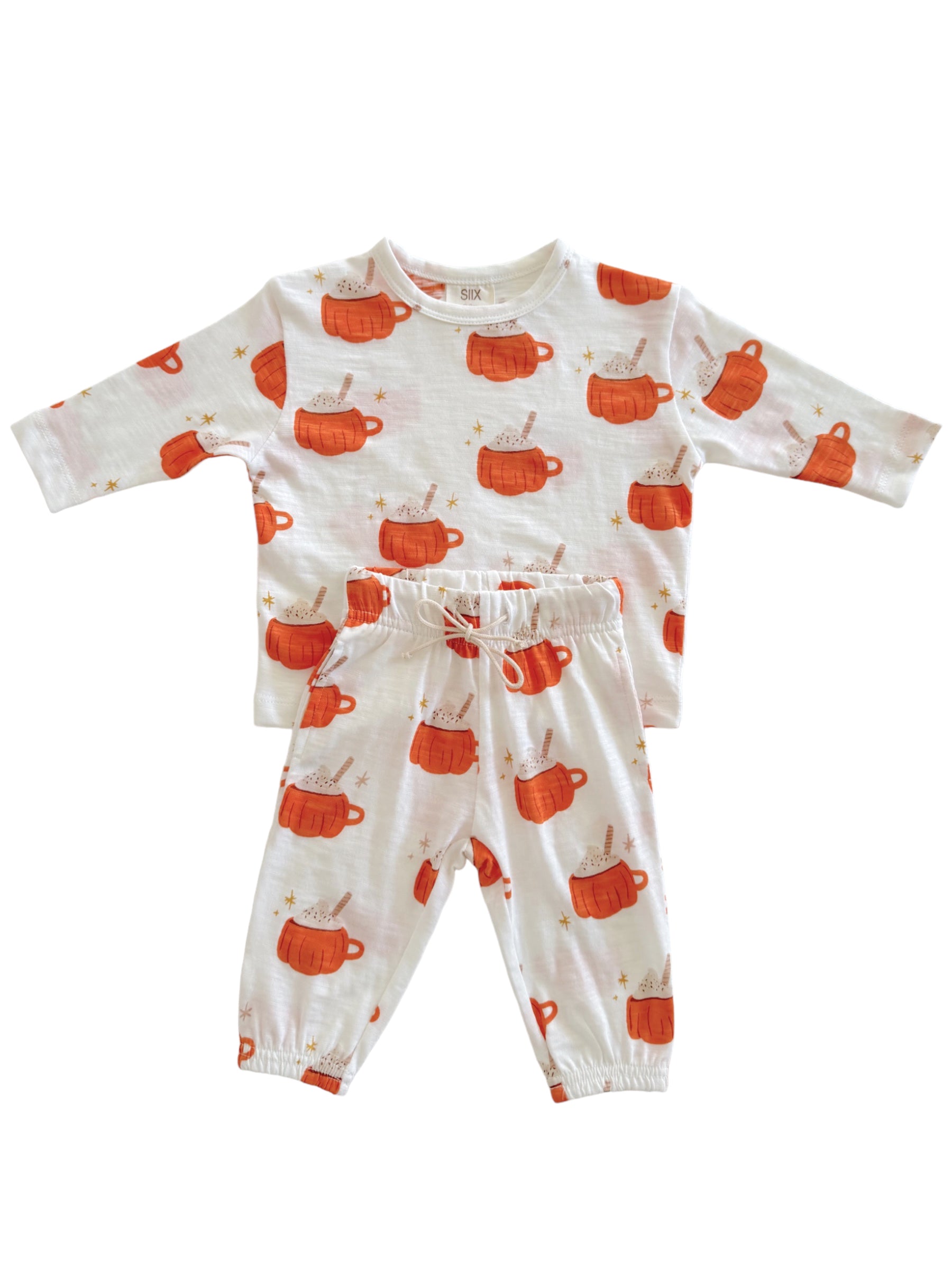 Children's pajama set featuring orange mugs with cream, stars, and a playful pattern on a white background.