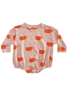 Baby outfit featuring a playful design of orange mugs with whipped cream on a light pink background.