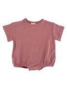 Pink short-sleeve onesie with a gathered bottom and colorful speckled pattern. Suitable for infants and toddlers.
