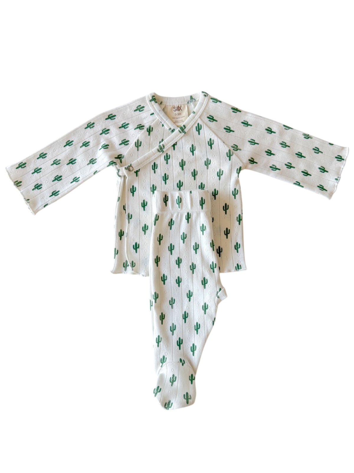 White baby outfit with green cactus print, featuring long sleeves and footed pants, laid flat on a neutral background.
