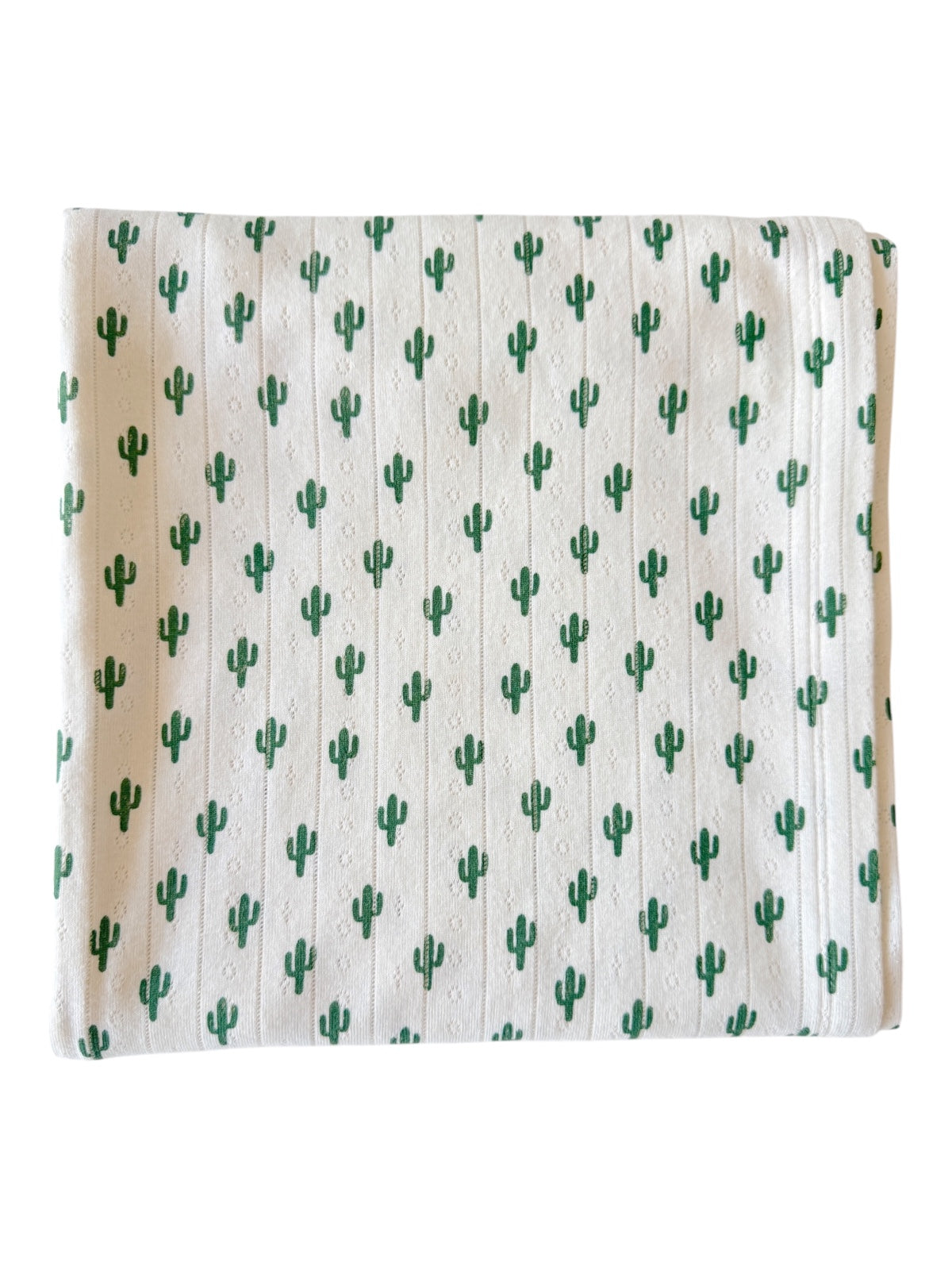 White fabric with a repeating green cactus pattern, folded neatly for display.