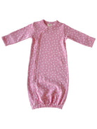 Soft pink baby gown with white floral pattern and long sleeves, featuring snap closures for easy dressing.