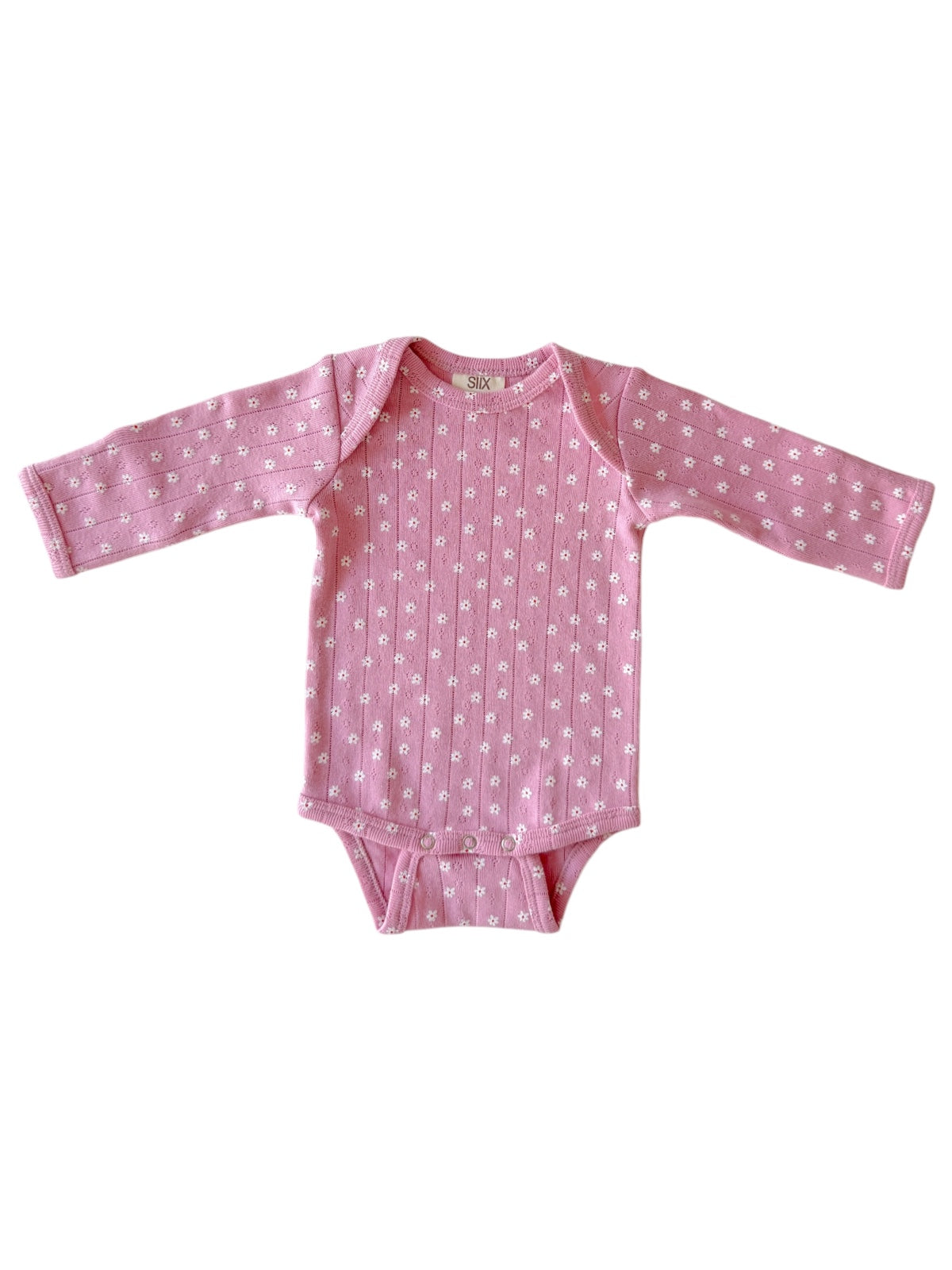 Pink long-sleeve baby onesie with white floral pattern and snap closures at the bottom.