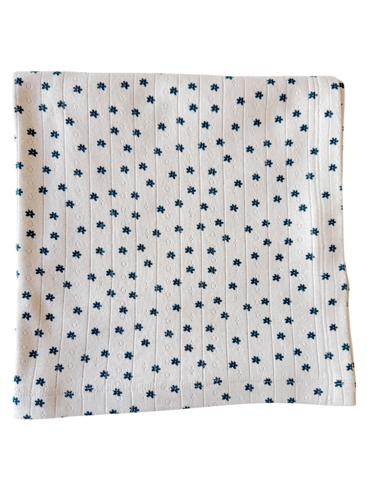 White fabric with small dark blue floral patterns and vertical stripes. Ideal for crafts or home décor.