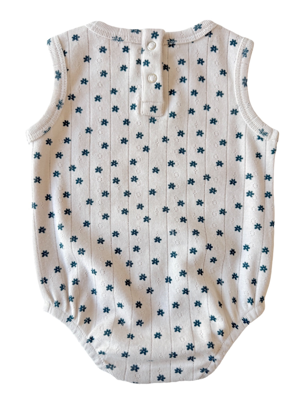 White sleeveless baby onesie with blue floral patterns and button closure at the back.