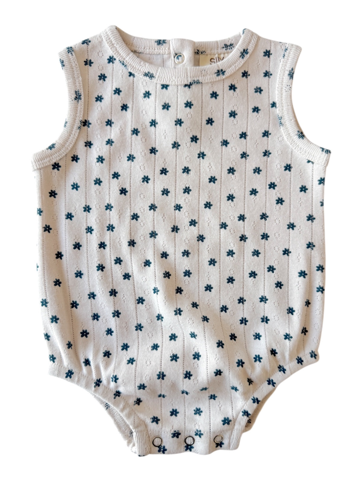White sleeveless baby romper with blue floral pattern and snap buttons at the bottom.