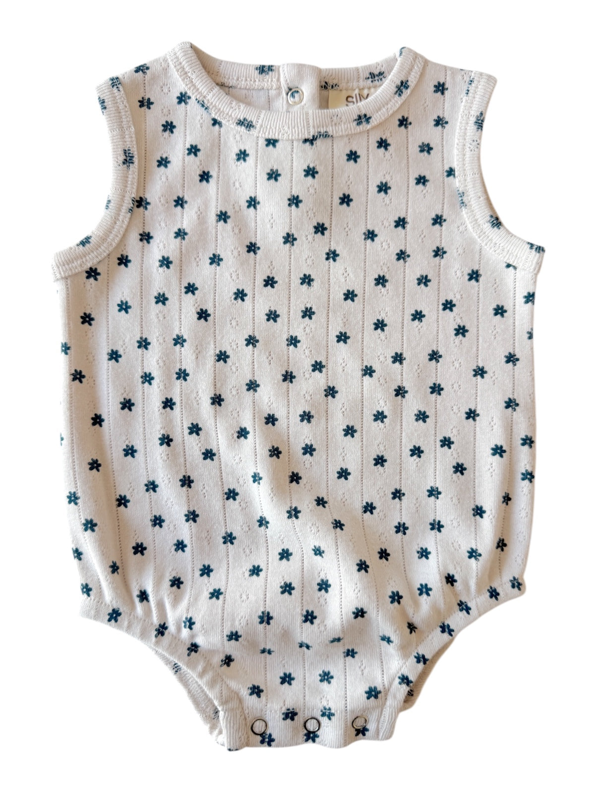 White sleeveless baby romper with blue floral pattern and snap buttons at the bottom.