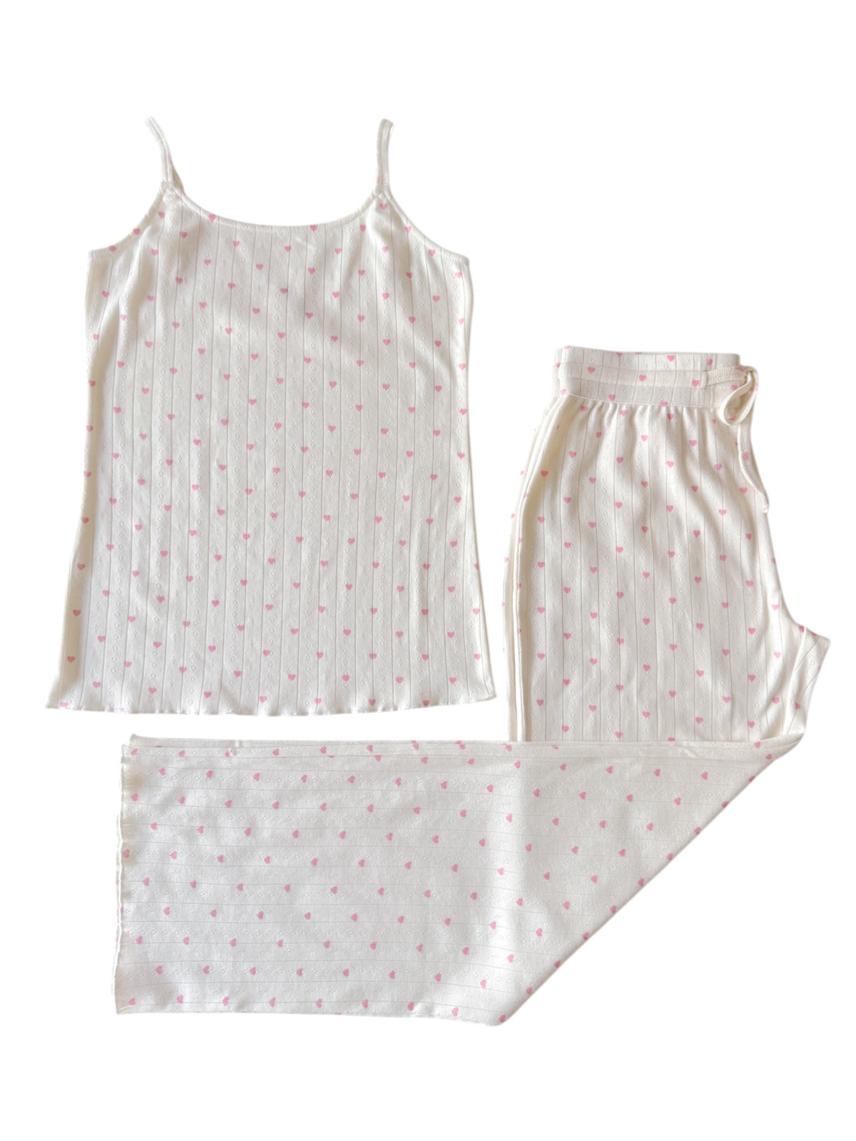 Lightweight sleepwear set featuring a tank top and matching pants with pink heart patterns on a white background.