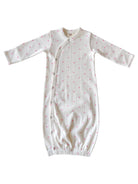 White baby gown with pink hearts, featuring long sleeves and button closures. Ideal for infant sleepwear.