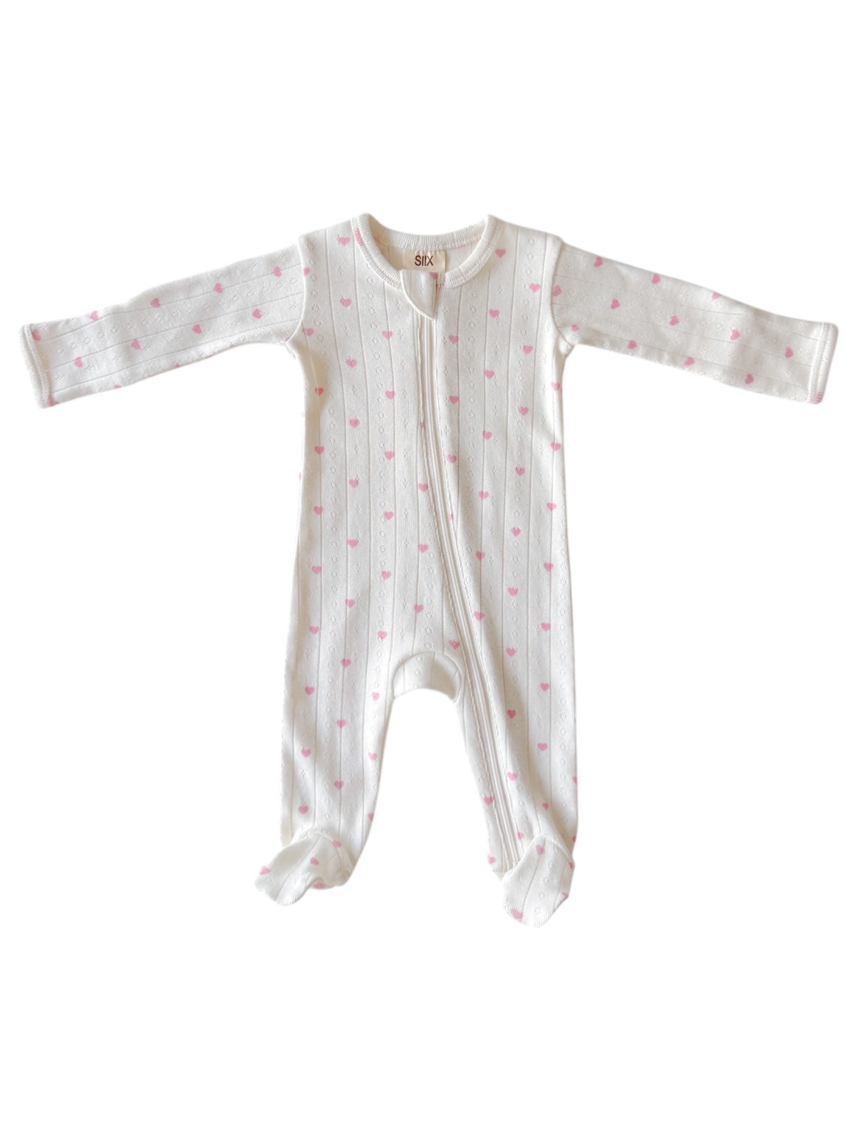 White baby onesie with pink hearts, long sleeves and footed design, featuring a front zipper closure.