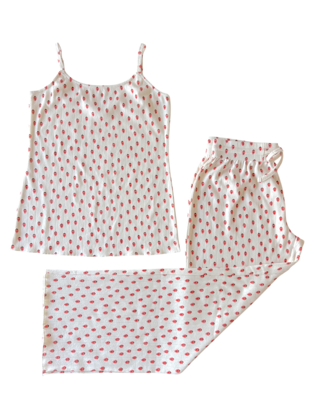 Women's pajama set featuring a spaghetti strap top and patterned shorts with small red dots on a white background.