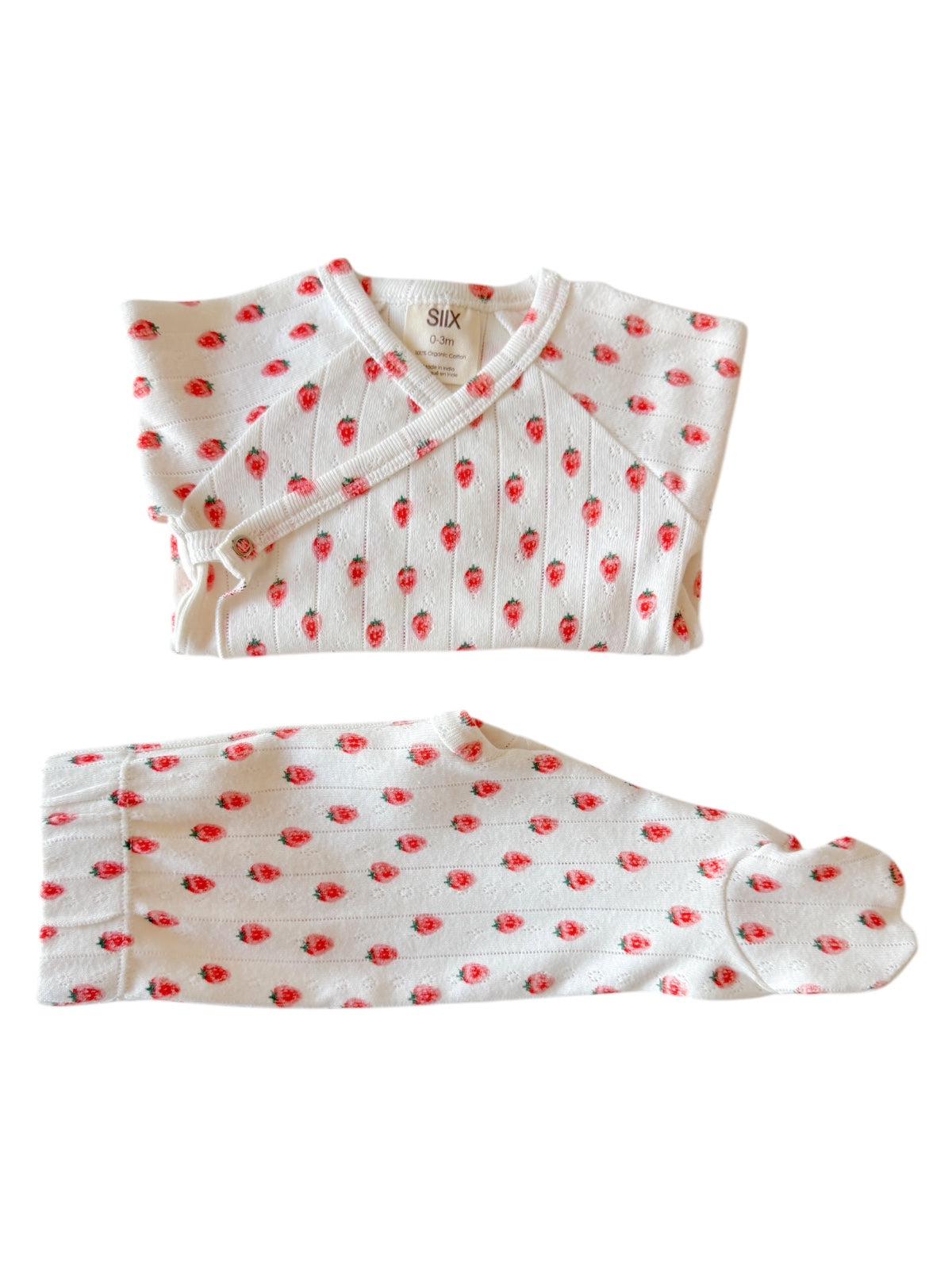 White baby outfit with red strawberry prints, includes top and footed pants, suitable for 0-3 months.